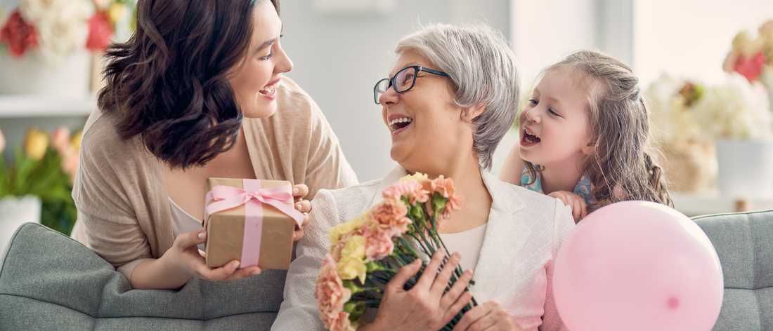 Kobiety w różnym wieku uśmiechają się do siebie wręczając najlepszy prezent na dzień mamy