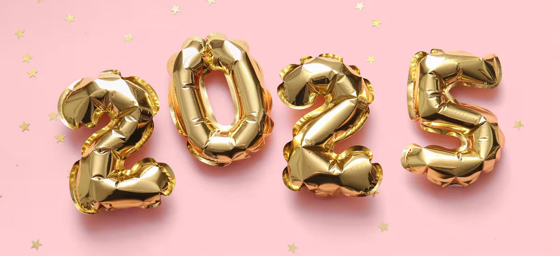 Złote balony w kształcie cyferek tworzących rok 2025 ułożone na różowym tle
