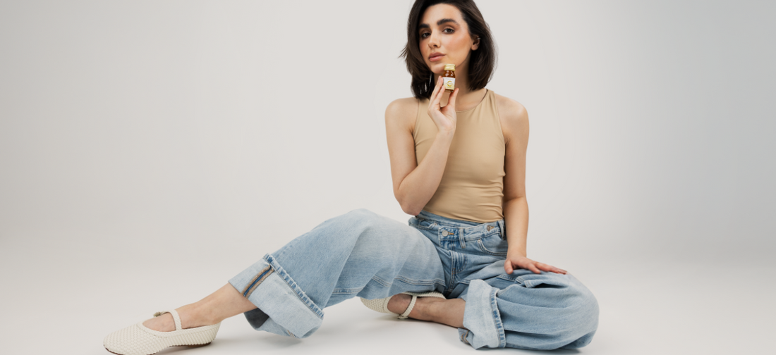 kobieta z promienną cerą i gęstymi włosami z buteleczką kolagenu Primabiotic