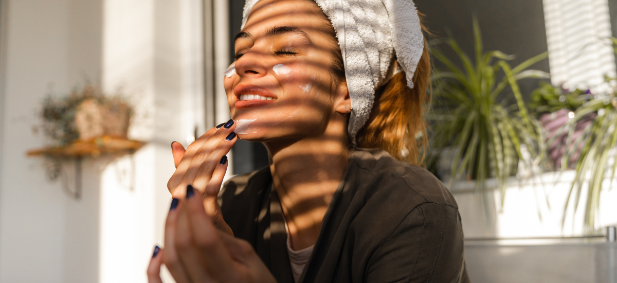 kobieta dba self care i nakłada krem na twarz
