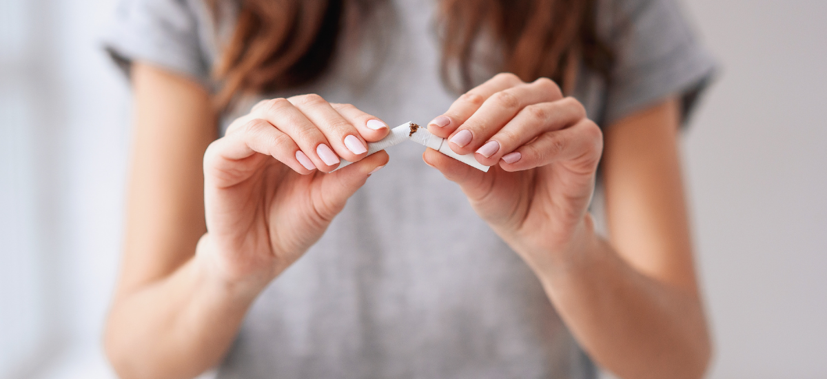 Kobieta rzuciła palenie i łamie papierosa na pół