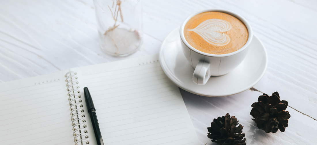 Capuccino ustawione na filiżance obok notesu