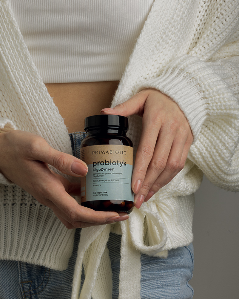 Kobieta trzyma probiotyk na jelita Primabiotic DigeZyme wspierający trawienie i komfort jelit