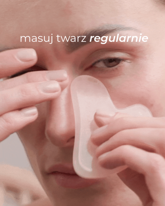 Modelka wykonuje masaż twarzy kamieniem gua sha