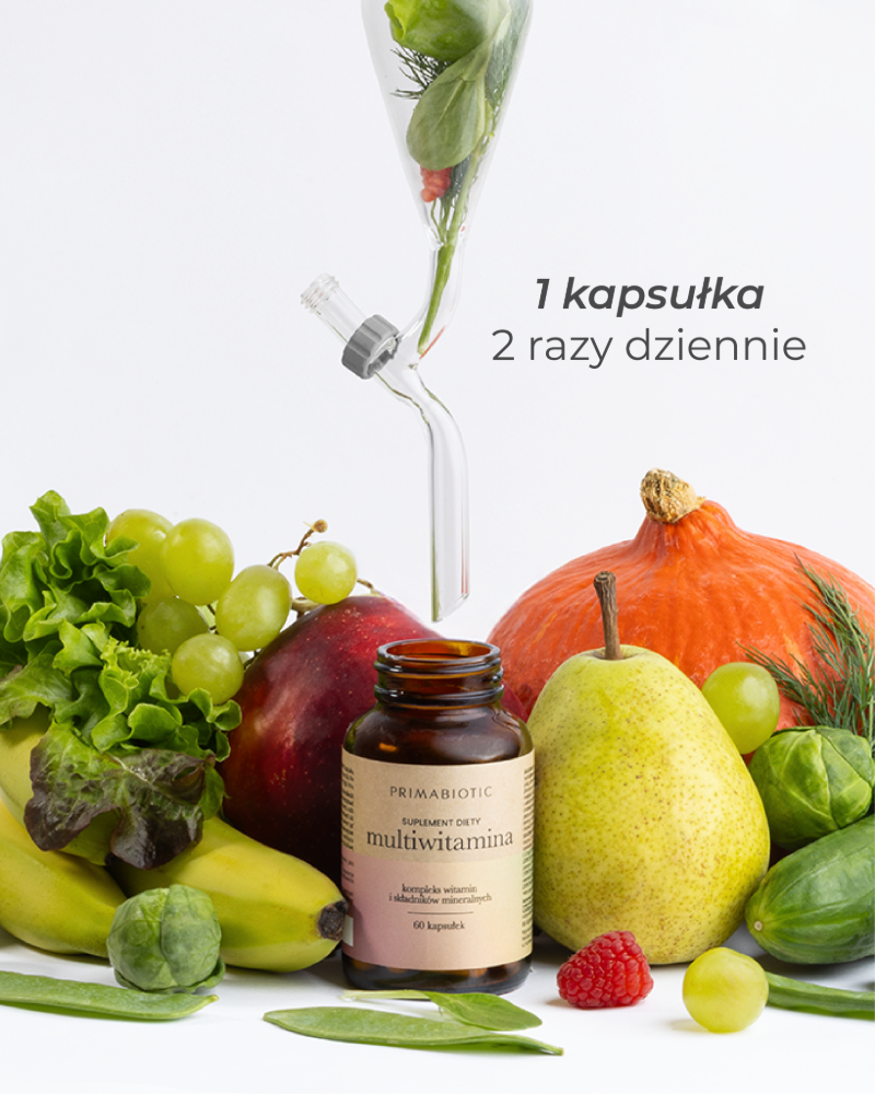 Opakowanie multiwitaminy Primabiotic na tle warzyw i owoców. Napis: 1 kapsułka 2 razy dziennie.