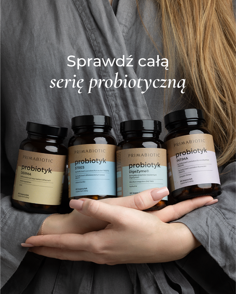 Kobieta o blond włosach trzyma serię probiotyków Primabiotic w kapsułkach wspierających jelita, skórę, trawienie i odporność