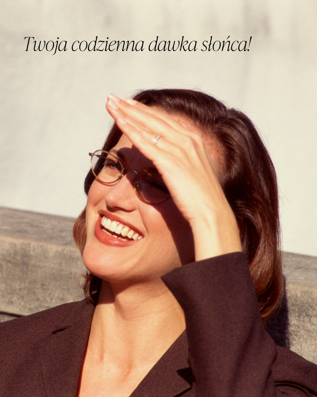 Kobieta uśmiecha się w promieniach słońca, czerpiąc naturalną dawkę witaminy D