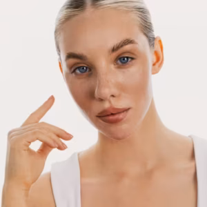 Blond kobieta o nawilżonej i gładkiej skórze twarzy patrzy prosto w obiektyw